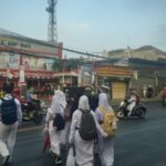 Anggota Unit Lantas Polsek Cileunyi Bantu Sebrangkan Pelajar di Jam Masuk Sekolah