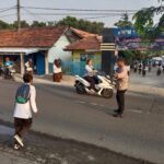 Bhabinkamtibmas Polsek Telagasari Bantu Siswa Menyebrang dan Pastikan Arus lalulintas Kondusif