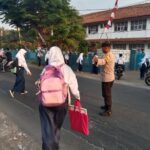 Optimalkan Pelayanan, Bhabinkamtibmas Polsek Telagasari Bantu Sebrangkan Siswa Saat Gatur