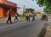 Bhabinkamtibmas Polsek Telagasari Giatkan Pengaturan Lalulintas dan Bantu Siswa Menyebrang