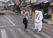 Peduli Keselamatan berlalu-lintas, Anggota Lantas Polsek Cileunyi bantu Sebrangkan Anak Sekolah