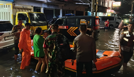 Personel Polres Tangsel bantu evakuasi warga terdampak banjir malam hari menggunakan perahu karet di kawasan Perumahan Paku Alam, Kecamatan Serpong Utara.