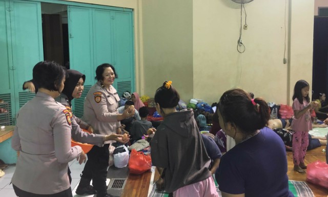 Polwan Ditpamobvit Polda Metro Jaya membagikan makanan di lokasi pengungsian banjir Jakarta Timur.