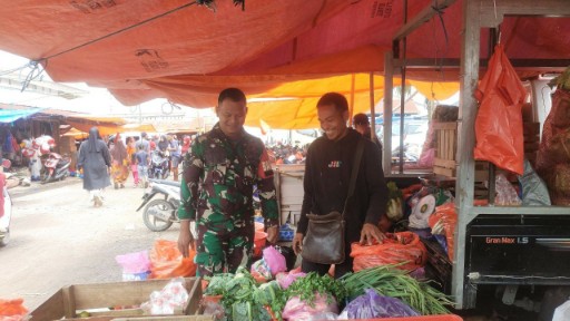 Babinsa Koramil Panca Rijang memantau harga bahan pokok di Pasar Sentral Rappang bersama pedagang.