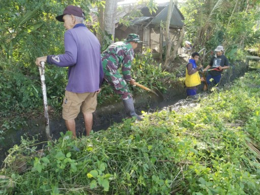 Babinsa Desa Timoreng Panua dan warga bersihkan saluran irigasi.