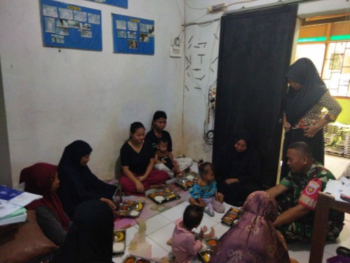 Personil Babinsa Koramil jajaran Kodim 1420/Sidrap dampingi penyaluran makanan bergizi kepada ibu dan balita di ruang sederhana.