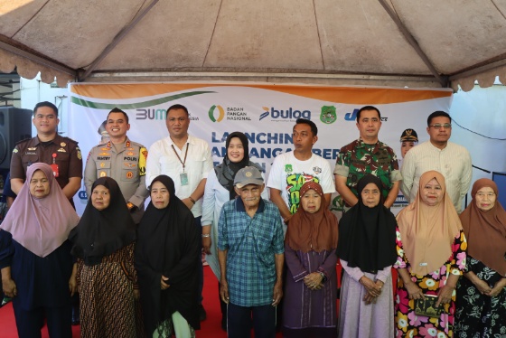 Sejumlah pejabat daerah, termasuk AKBP Dr. Fantry, berfoto bersama warga penerima bantuan beras di Sidrap.