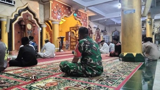 Seorang Babinsa Kodim 1420 Sidrap duduk bersila di dalam masjid saat mengikuti shalat Subuh berjamaah bersama warga.