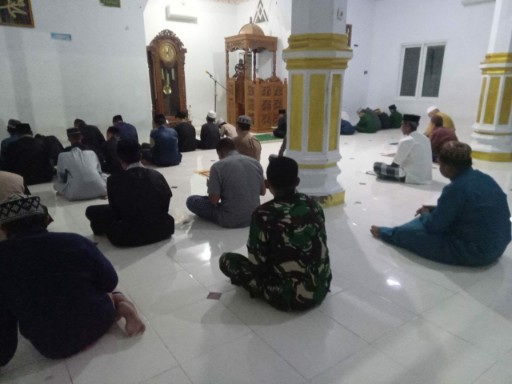 Babinsa duduk bersama warga saat mengikuti shalat subuh berjamaah di dalam masjid.