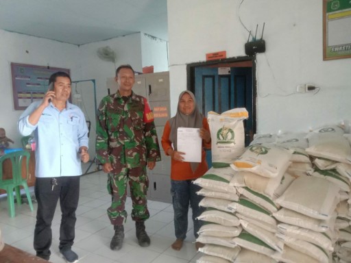 Babinsa mendampingi warga saat penyaluran bantuan beras pemerintah di Kelurahan Toddang Pulu.