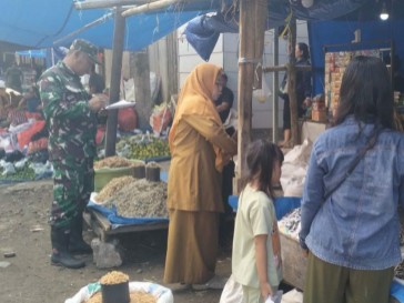 Babinsa Kelurahan Pangkajene memantau harga sembako di pasar.