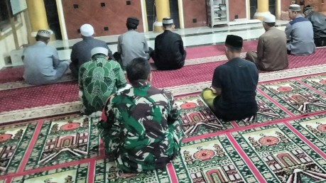 Personil Bintara Pembina Desa dan sejumlah warga duduk bersila dalam saf salat Subuh berjamaah di masjid desa.