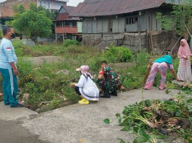 Babinsa Kelurahan Majeling Wattang dan warga membersihkan saluran air dalam kegiatan karya bakti.