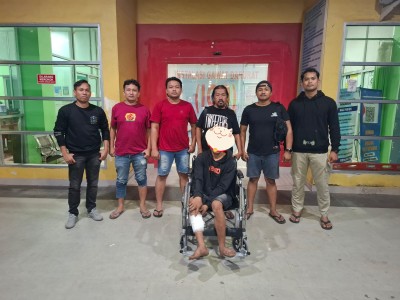 Seorang tersangka pencurian kabel duduk di kursi roda dengan luka tembak di kedua kakinya, dikelilingi enam anggota Tim Pegasus Resmob Jeneponto.