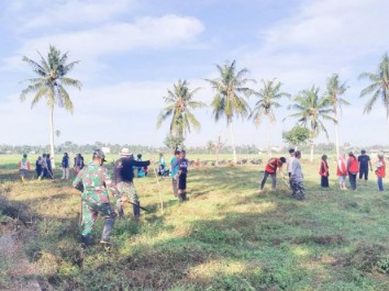 Babinsa Desa Paseno, warga dan mahasiswa KKN Unhas gotong royong membersihkan lapangan di Desa Paseno
