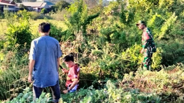 Babinsa Uluale memimpin pembersihan saluran air bersama warga di semak belukar.