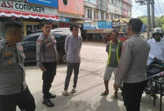 Petugas Satgas Polda Sultra berdialog dengan juru parkir di Pasar Panjang, Kendari.