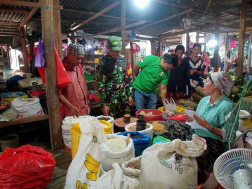 Babinsa Kelurahan Tanru Tedong  berinteraksi dengan pedagang di pasar tradisional memantau harga bahan pokok.