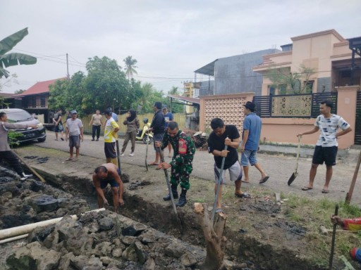 Babinsa Kelurahan Benteng bersama warga gotong royong membersihkan saluran air di Baranti, Sidrap.