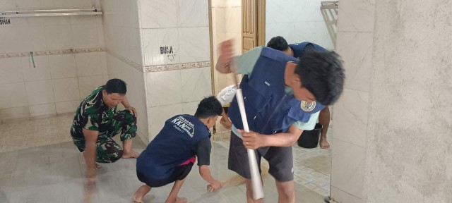 Babinsa Kelurahan Benteng bersama mahasiswa KKN membersihkan masjid.