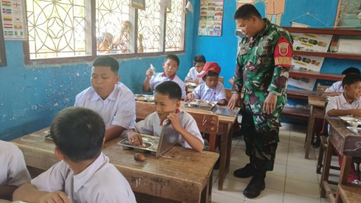 Babinsa Kodim 1420/Sidrap mendampingi pembagian makanan bergizi gratis kepada siswa SD di Sidrap.