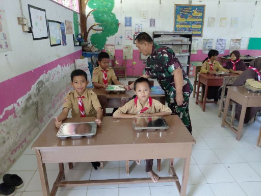 Babinsa Kodim 1420/Sidrap mendampingi siswa saat pendistribusian makan bergizi gratis di sekolah Kabupaten Sidrap.