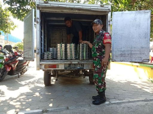 Babinsa Kodim 1420/Sidrap membantu pendistribusian makanan bergizi gratis dari mobil logistik untuk warga Sidrap.