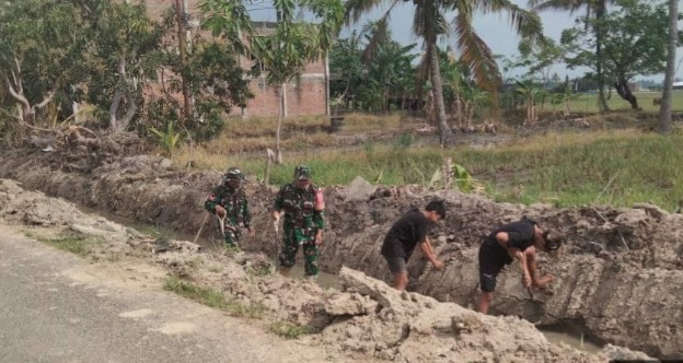 Babinsa Koramil 1420-04 Watang Pulu kerja bakti bersama warga membersihkan saluran irigasi di Desa Cirociroe Sidrap.