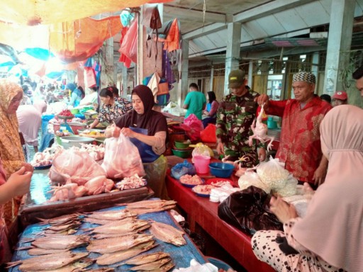 Babinsa Koramil 05/Dua Pitue bersama pedagang pasar saat melakukan pemantauan harga bahan pokok di Pasar Sentral Tanru Tedong, Sidrap.