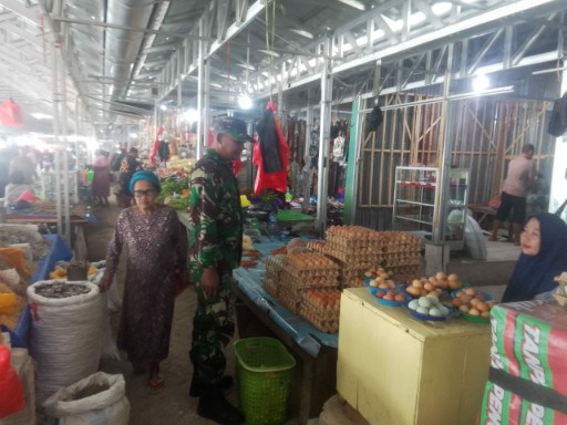 Babinsa Koramil 04/Watang Pulu Serda Hasdi memantau harga kebutuhan pokok di Pasar Lawawoi Sidrap bersama pedagang untuk menjaga stabilitas harga dan stok pangan masyarakat.