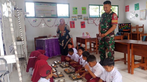 Babinsa Kodim 1420/Sidrap mendampingi anak-anak sekolah menikmati makanan bergizi dalam program Makanan Bergizi Gratis di Sidrap.