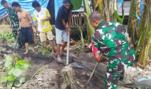 Anggota TNI Koramil 07 Baranti bersama warga membersihkan selokan dalam kegiatan Karya Bakti di Desa Sipudeceng, Sidrap.