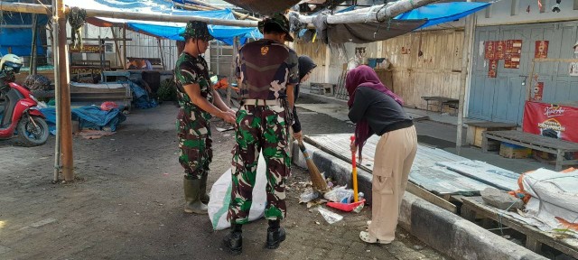 Anggota TNI dari Koramil 1420-03/Maritengngae bersama warga bergotong royong membersihkan area Pasar Sentral Pangkajene, Sidrap.