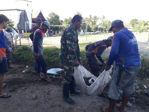 Personel Koramil 01/Panca Lautang bersama warga Desa Lise bergotong royong membersihkan parit di Lapangan Kapitan Bolong, Sidrap.