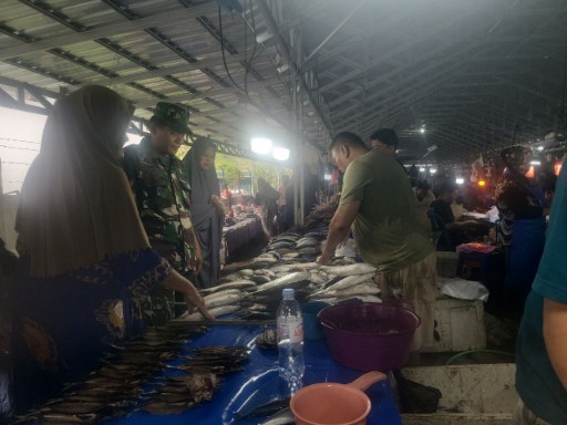 Babinsa Koramil 04/Watang Pulu memantau harga ikan di Pasar Tradisional Lawawoi, Sidrap, sambil berdialog dengan pedagang untuk memastikan stabilitas harga bahan pokok.