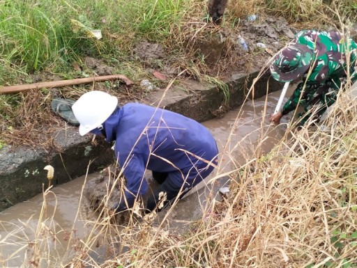 Babinsa Koramil 05/Dua Pitue Serda Syampraja bersama warga membersihkan saluran air di Desa Padangloang Alau, Sidrap, untuk mencegah banjir.