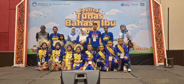 Pelajar Sidrap berfoto bersama guru dan pendamping seusai tampil dalam Festival Tunas Bahasa Ibu 2025 di Hotel Dalton Makassar, mengenakan busana adat warna biru dan emas dengan ekspresi penuh semangat dan kebanggaan.