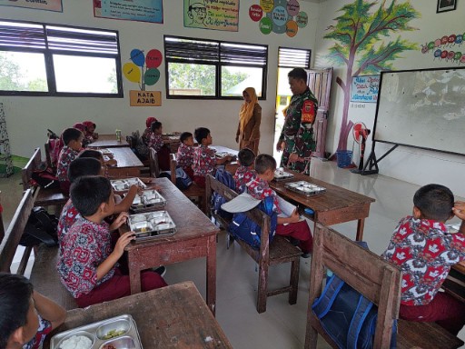 Babinsa Ramil 1420/Sidrap mendampingi pembagian makanan bergizi kepada siswa sekolah dasar di Sidrap.