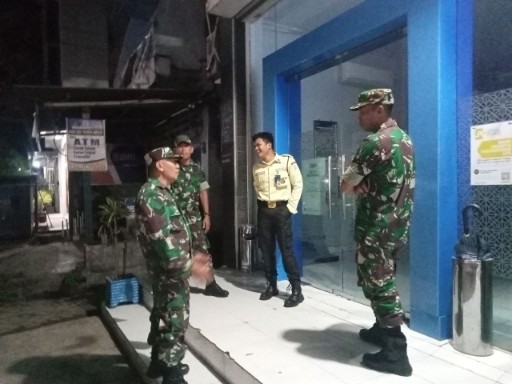Babinsa Sidrap dari Koramil 1420-06 Panca Rijang bersama Satpam melaksanakan patroli malam Siskamling di area perbankan Kecamatan Rappang untuk menjaga keamanan warga.
