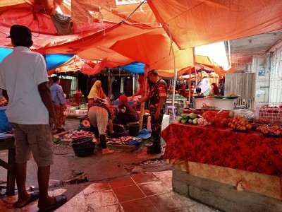 Babinsa Koramil 06 Panca Rijang memantau harga dan ketersediaan bahan pokok di Pasar Sentral Rappang, Sidrap, sambil berdialog dengan pedagang.