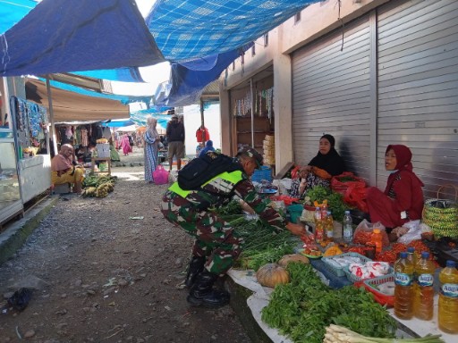 Babinsa memantau harga bahan pokok di Pasar Tradisional Lancirang, berbincang dengan pedagang sambil memastikan stabilitas pangan di wilayah binaannya.
