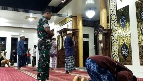 Seorang Babinsa berseragam TNI berdiri khusyuk mengikuti Salat Subuh berjamaah bersama warga di dalam masjid, dalam kegiatan Safari Subuh di wilayah binaan.
