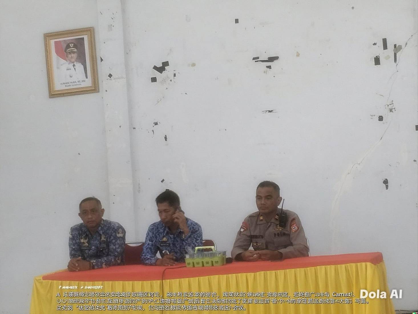 Tiga pejabat duduk di meja rapat sederhana, termasuk seorang polisi berseragam, saat membahas situasi terkait aksi warga Bontoraya di kantor kecamatan.