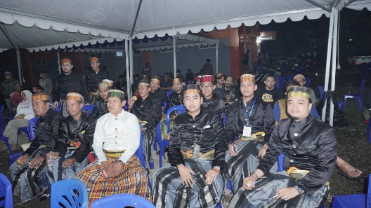 Para peserta dan tamu pameran pusaka mengenakan busana adat Bugis berwarna hitam dengan passapu duduk di area acara budaya di Sidrap.