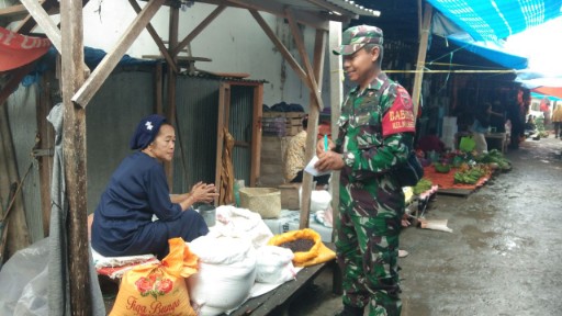 Babinsa melakukan pemantauan harga dan ketersediaan bahan pokok di Pasar Sentral Amparita, berdialog dengan pedagang untuk memastikan stabilitas kebutuhan masyarakat.