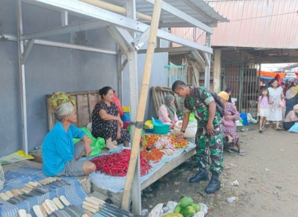 Anggota Ramil 02 Tellu Limpoe, Serka Anwar, memantau harga bahan pokok di Pasar Sentral Amparita sambil berdialog dengan pedagang.