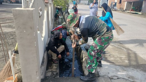 Personel TNI Koramil Maritengngae bersama warga membersihkan selokan di Kelurahan Wala, Sidrap, dalam kegiatan karya bakti lingkungan.