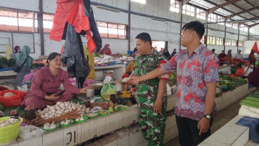 Babinsa Koramil 1420-07/Baranti memantau harga sembako di Pasar Sentral Baranti sambil berdialog dengan pedagang untuk memastikan stabilitas harga dan ketersediaan stok.