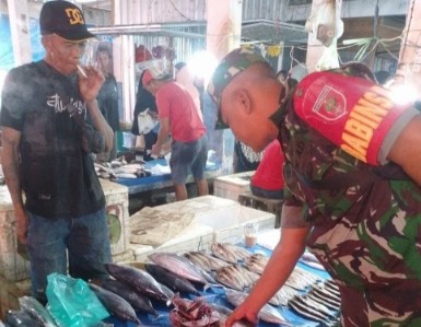Babinsa memantau harga dan stok ikan di Pasar Dongi, Sidrap, saat berinteraksi dengan pedagang setempat.