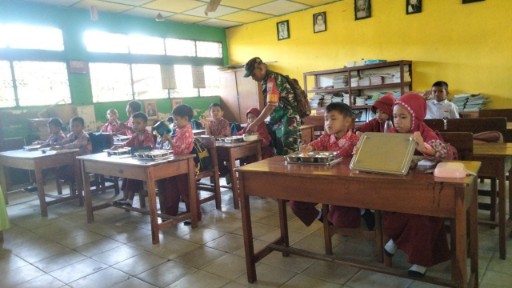 Babinsa Koramil Kodim 1420 Sidrap dampingi siswa saat pembagian makan bergizi gratis di sekolah. 